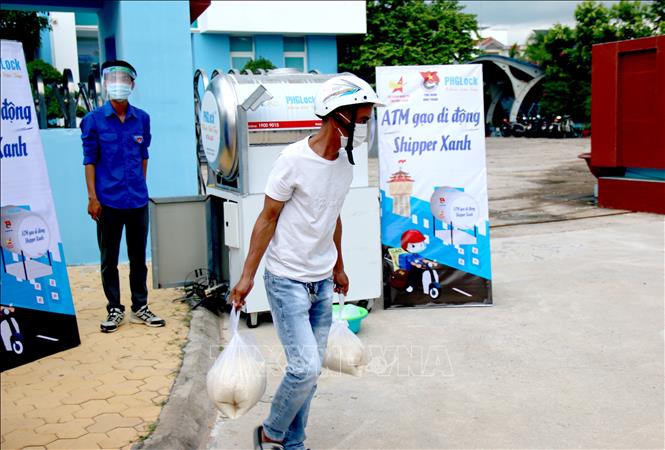 Một người dân được lấy hai túi gạo tại “ATM gạo di động - Shipper xanh” đặt tại Tỉnh đoàn Bình Thuận tương đương 10 kg gạo. Ảnh: Nguyễn Thanh - TTXVN
