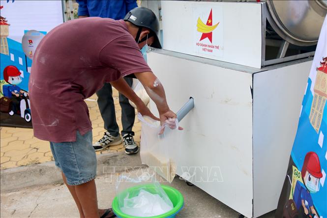 Người dân lấy gạo tại “ATM gạo di động - Shipper xanh” đặt tại Tỉnh đoàn Bình Thuận. Ảnh: Nguyễn Thanh - TTXVN