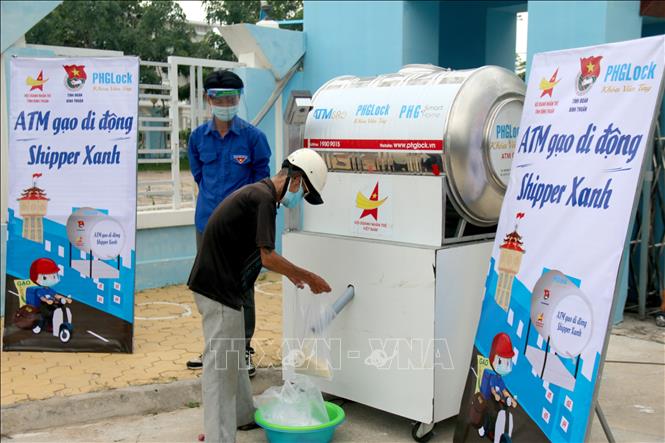 Người dân lấy gạo tại “ATM gạo di động - Shipper xanh” đặt tại Tỉnh đoàn Bình Thuận. Ảnh: Nguyễn Thanh - TTXVN