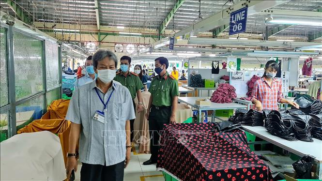 Trong ảnh: Giám đốc Sở Công Thương Phan Văn Sáu và các thành viên trong Đoàn kiểm tra thực tế công nhân ở các xưởng may. Ảnh: Chanh Đa-TTXVN