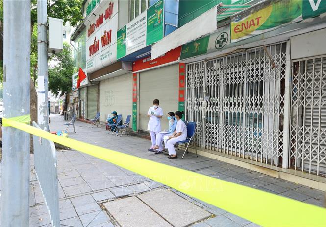 Trong ảnh: Y tế quận Hoàn Kiếm và lực lượng an ninh túc trực tại khu vực bị phong tỏa. Ảnh: Hoàng Hiếu - TTXVN 
