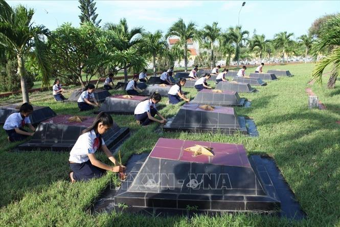 Trong ảnh: Học sinh trường THCS Trần Hưng Đạo, tỉnh Phú Yên chăm sóc phần mộ liệt sĩ tại Nghĩa trang liệt sĩ Đông Tác. Ảnh: Anh Tuấn - TTXVN