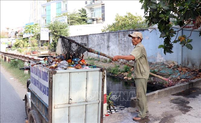 Trong ảnh: Hơn 6 năm qua, hai lần mỗi ngày, thương binh 4/4 Nguyễn Ngọc Đức (phường Bình Trị Đông, quận Bình Tân, TP. Hồ Chí Minh) lại cần mẫn vớt rác trên dòng kênh Chiến Lược. Việc làm kiên trì, của người thương binh ấy không chỉ làm sống lại một con kênh chết mà còn góp phần xây dựng ý thức bảo vệ môi trường cho người dân trong khu vực. Ảnh: Xuân Khu-TTXVN