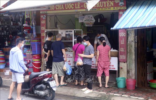 Trong ảnh: Nhiều người dân không tuân thủ việc giãn cách khi đi chợ. Ảnh: Tuấn Đức - TTXVN