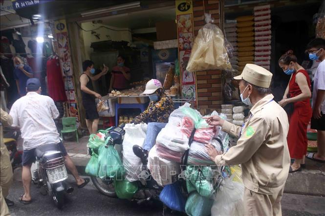 Trong ảnh: Lực lượng chức năng liên tục nhắc nhở người dân tránh tụ tập đông người, đảm bảo giãn cách. Ảnh: Tuấn Đức - TTXVN