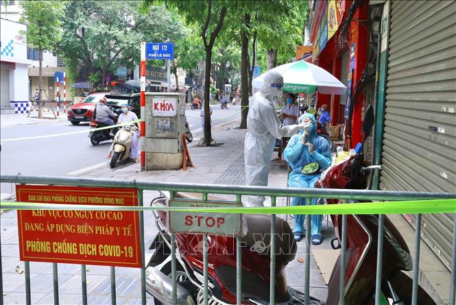 Nhân viên y tế quận Hai Bà Trưng lấy mẫu xét nghiệm cư dân trong ngõ 172 Lò Đúc. Ảnh: Hoàng Hiếu - TTXVN