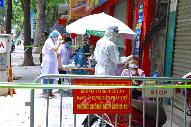 Nhân viên y tế quận Hai Bà Trưng lấy mẫu xét nghiệm cư dân trong ngõ 172 Lò Đúc. Ảnh: Hoàng Hiếu - TTXVN