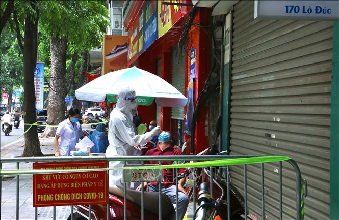 Nhân viên y tế quận Hai Bà Trưng lấy mẫu xét nghiệm cư dân trong ngõ 172 Lò Đúc. Ảnh: Hoàng Hiếu - TTXVN