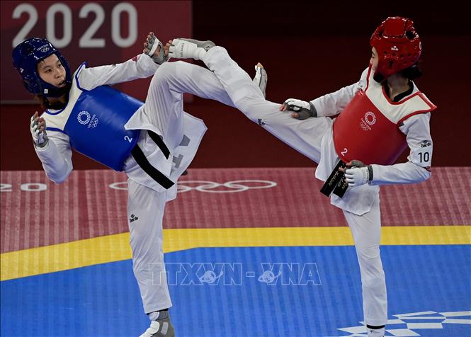 Trong ảnh: Nữ võ sĩ Trương Thị Kim Tuyền (trái) trong trận tứ kết hạng cân dưới 49kg nữ, môn Taekwondo, gặp đối thủ Panipak Wongpattanakit người Thái Lan ở Olympic Tokyo 2020, tại Nhật Bản, ngày 24/7/2021. Ảnh: AFP/TTXVN
