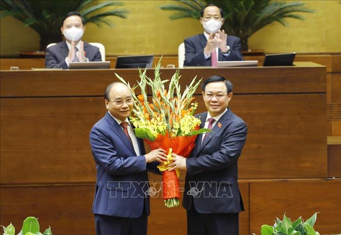 Photo: NA Chairman Vuong Dinh Hue (R) congratulates the newly-elected State President on July 26. VNA Photo