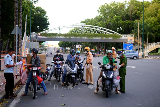 Trong ảnh: Đúng 18 giờ ngày 26/7, lực lượng chức năng làm nhiệm vụ tại chốt kiểm soát trên đường Hoàng Minh Giám, quận Phú Nhuận. Ảnh: Thành Chung - TTXVN
