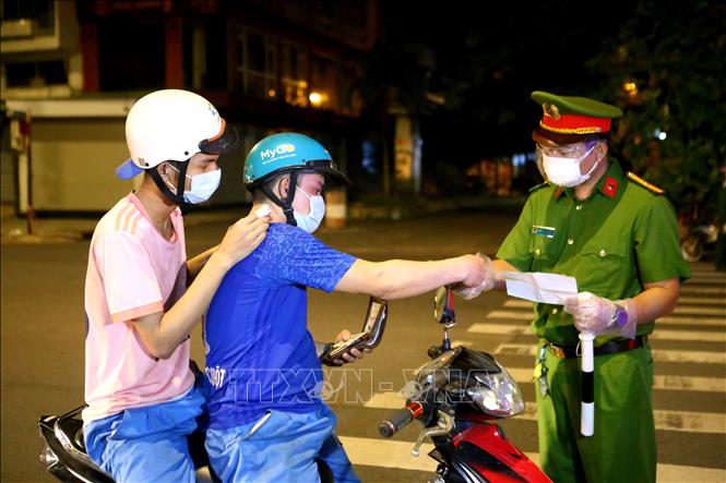 Trong ảnh: Một trường hợp ra đường vì lý do thiết yếu được giải quyết tiếp tục lưu thông. Ảnh: Thành Chung - TTXVN