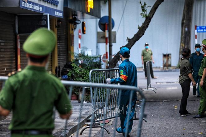 Trong ảnh: Lực lượng chức năng phường Hàng Bài lập rào chắn phong tỏa phố Vọng Đức và số nhà 39 Hàng Bài sau khi có thông tin 1 bệnh nhân dương tính với SARS-CoV-2. Ảnh: Thành Đạt - TTXVN 
