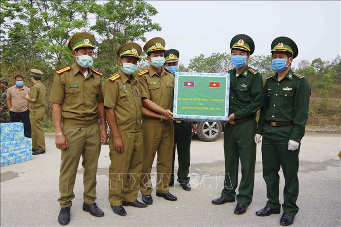Trong ảnh: Ngày 11/4/2020, tại khu vực Mốc 113, Bộ Chỉ huy Bộ đội Biên phòng tỉnh Điện Biên tặng quà có trị giá 100 triệu đồng cho các lực lượng quản lý, bảo vệ biên giới của ba tỉnh Luang Prabang, Phongsaly, Oudomxay (CHDCNDn Lào) về hợp tác phòng, chống dịch COVID-19. Ảnh: Phan Tuấn Anh - TTXVN