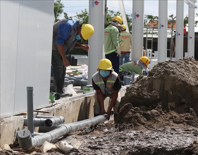 Trong ảnh: Các hạng mục phụ trợ tại bệnh viện dã chiến trên đường Nguyễn Văn Linh đang được khẩn trương thi công. Ảnh: Trần Xuân Tình - TTXVN
