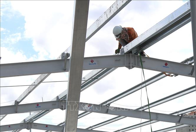 Trong ảnh: Lắp ráp khung thép của bệnh viện dã chiến trên đường Nguyễn Văn Linh. Ảnh: Trần Xuân Tình - TTXVN