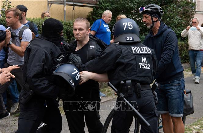 Trong ảnh: Cảnh sát bắt giữ người biểu tình quá khích tại Berlin, Đức ngày 1/8/2021. Ảnh: AFP/TTXVN