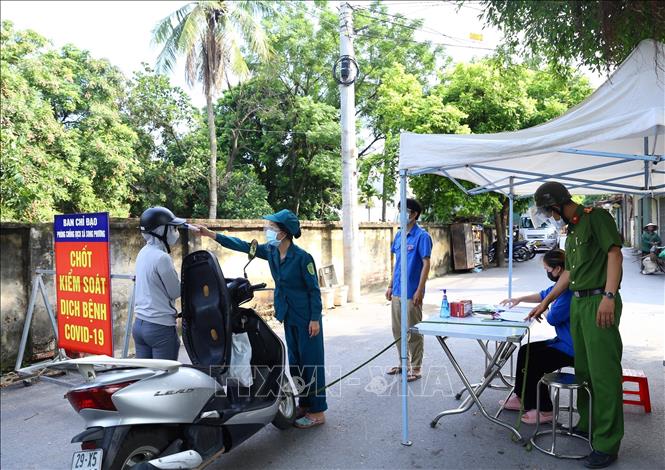 Các lực lượng công an, đoàn viên thanh niên, phụ nữ, cựu chiến binh thực hiện nhiệm vụ tại chốt kiểm soát thôn Phương Bảng, xã Song Phương. Ảnh: Hoàng Hiếu - TTXVN