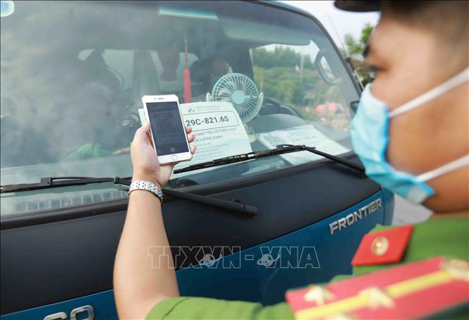 Công an kiểm tra phương tiện giao thông bằng phương pháp quét mã QR Code tại chốt kiểm soát trên Đê sông Đáy, xã Song Phương, huyện Hoài Đức. Ảnh: Vũ Sinh - TTXVN 