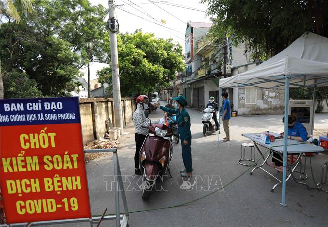 Lực lượng chức năng làm nhiệm vụ tại chốt kiểm soát thôn Phương Bảng, xã Song Phương. Ảnh: Vũ Sinh - TTXVN