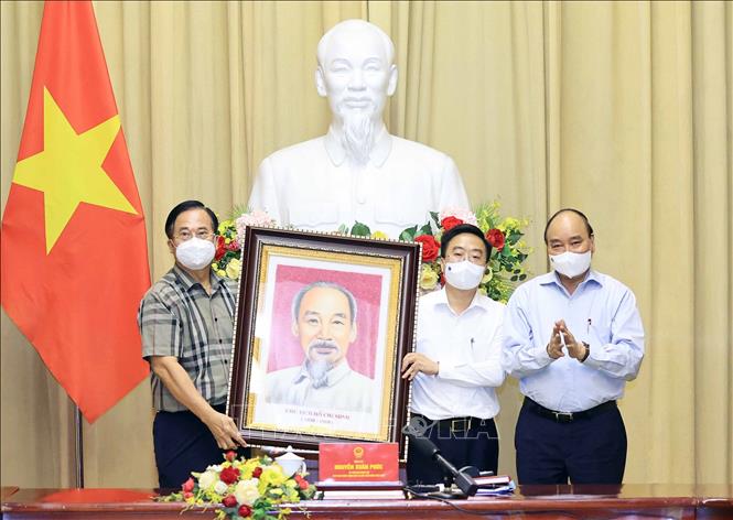 Trong ảnh: Chủ tịch nước Nguyễn Xuân Phúc tặng bức ảnh Bác Hồ cho đại diện các đại biểu ngành Dệt may. Ảnh: Thống Nhất - TTXVN