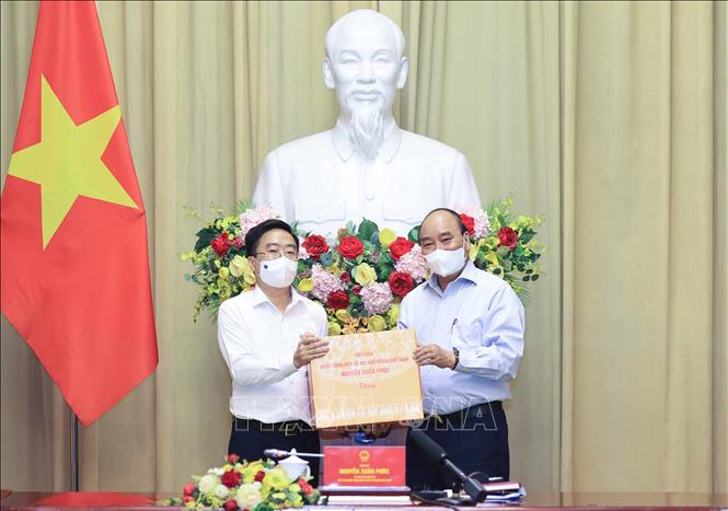 Trong ảnh: Chủ tịch nước Nguyễn Xuân Phúc tặng quà lưu niệm cho các đại biểu tại buổi gặp mặt. Ảnh: Thống Nhất - TTXVN