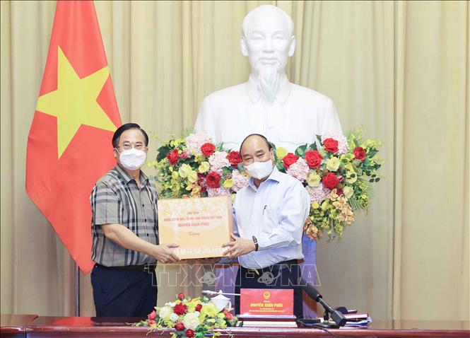 Trong ảnh: Chủ tịch nước Nguyễn Xuân Phúc tặng quà lưu niệm cho các đại biểu tại buổi gặp mặt. Ảnh: Thống Nhất – TTXVN
