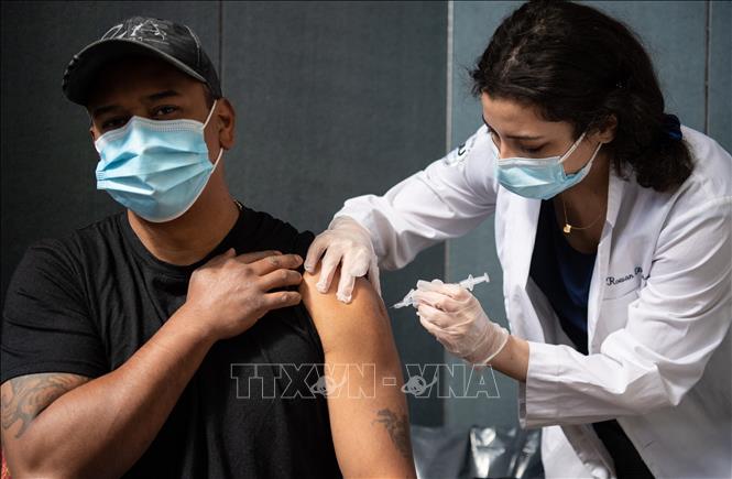 Trong ảnh: Nhân viên y tế tiêm vaccine ngừa Covid-19 cho người dân tại New York, Mỹ ngày 16/4/2021. Ảnh: AFP/TTXVN