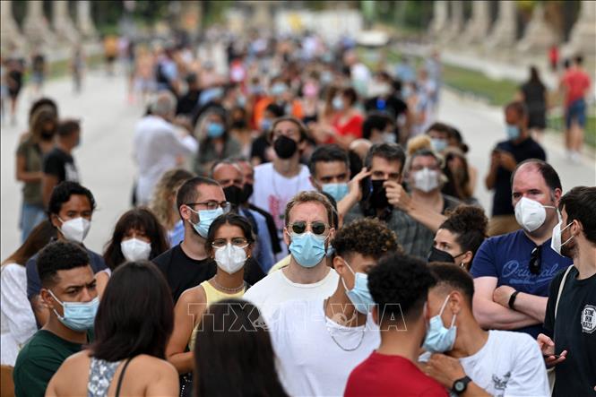 Trong ảnh: Người dân xếp hàng chờ tiêm vaccine ngừa COVID-19 tại Barcelona, Tây Ban Nha ngày 7/7/2021. Ảnh: AFP/TTXVN