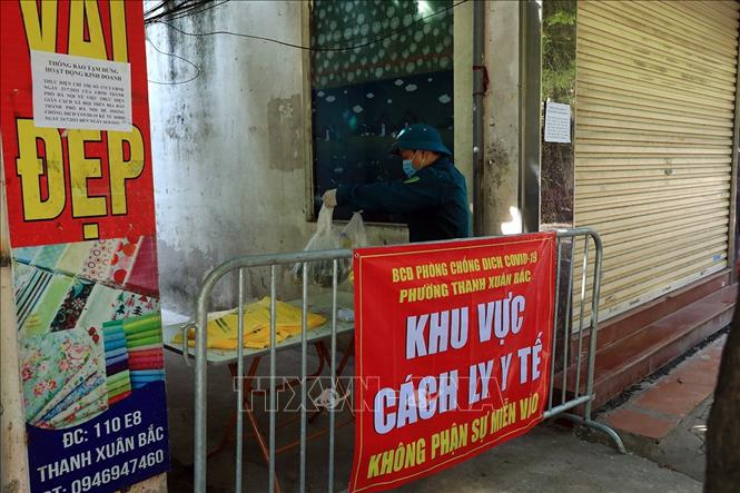  Lực lượng quân sự phường Thanh Xuân Bắc hỗ trợ mua, chuyển thực phẩm cho người dân trong khu vực phong tỏa. Ảnh: Tuấn Anh - TTXVN