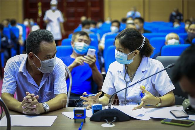 Trong ảnh: Bác sĩ tư vấn cho người dân trước khi tiêm vaccine phòng COVID-19 của Pfizer/BioNTech. Ảnh: Trọng Đạt - TTXVN 