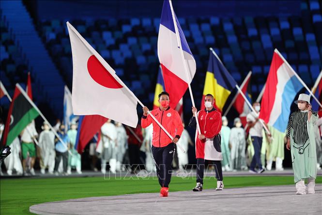 Trong ảnh: Đại diện các đoàn thể thao cầm cờ tiến vào sân vận động Olympic ở Tokyo, Nhật Bản trong lễ bế mạc Olympic Tokyo 2020 ngày 8/8/2021. Ảnh: THX/TTXVN