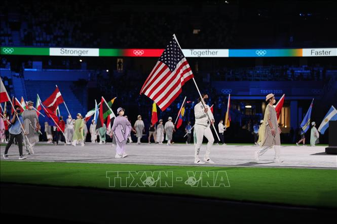 Trong ảnh: Đại diện các đoàn thể thao cầm cờ tiến vào sân vận động Olympic ở Tokyo, Nhật Bản trong lễ bế mạc Olympic Tokyo 2020 ngày 8/8/2021. Ảnh: THX/TTXVN