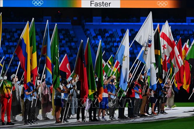 Trong ảnh: Đại diện các đoàn thể thao cầm cờ diễu hành trên sân vận động Olympic ở Tokyo, Nhật Bản trong lễ bế mạc Olympic Tokyo 2020 ngày 8/8/2021. Ảnh: AFP/TTXVN