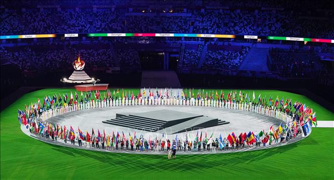 Trong ảnh: Đại diện các đoàn thể thao cầm cờ tạo thành vòng tròn trên sân vận động Olympic ở Tokyo, Nhật Bản trong lễ bế mạc Olympic Tokyo 2020 ngày 8/8/2021. Ảnh: THX/TTXVN