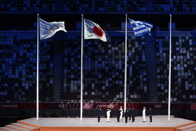 Trong ảnh: Quốc kỳ Hy Lạp, quê hương của Olympic, được kéo lên bên cạnh cờ Olympic (trái) và quốc kỳ Nhật Bản (giữa) tại lễ bế mạc Olympic Tokyo 2020 trên sân vận động Olympic ở Tokyo, Nhật Bản ngày 8/8/2021. Ảnh: AFP/TTXVN 