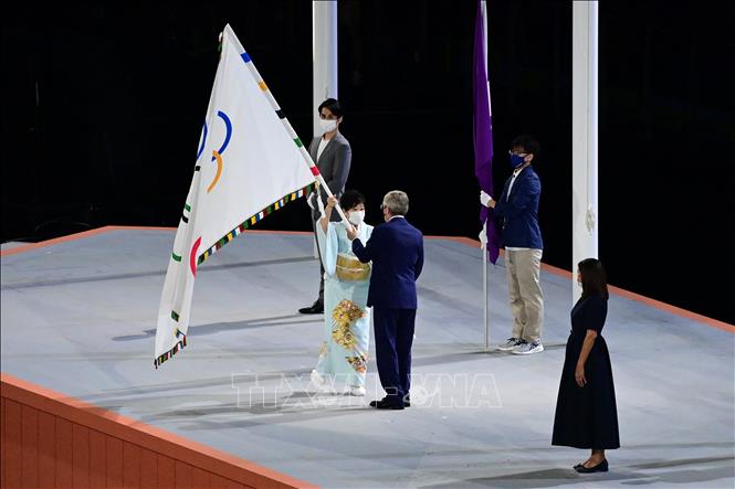 Trong ảnh: Thống đốc Tokyo (Nhật Bản), bà Yuriko Koike (trái) trao lá cờ Olympic cho Chủ tịch IOC Thomas Bach để chuyển cho bà Ana Maria Hidalgo (phải), Thị trưởng Paris (Pháp) - thành phố đăng cai Olympic mùa Hè 2024. Ảnh: AFP/TTXVN