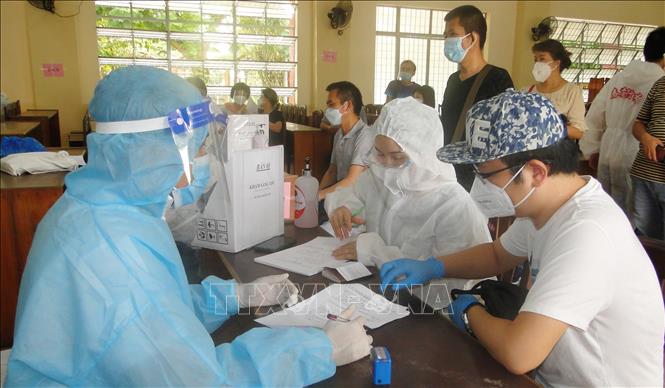 Trong ảnh: Công dân Trung Quốc hoàn thiện phiếu tiêm chủng vaccine. Ảnh: Hữu Chí - TTXVN