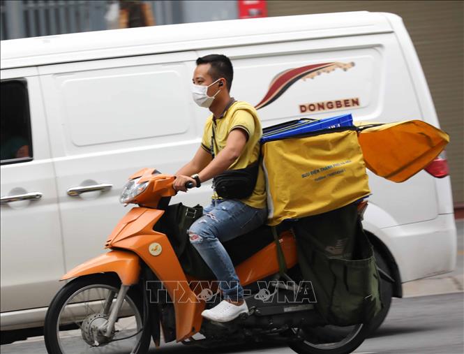 Trong ảnh: Nhân viên giao hàng không đội mũ bảo hiểm khi di chuyển trên phố (ảnh chụp sáng 10/8/2021). Ảnh: Thanh Tùng - TTXVN