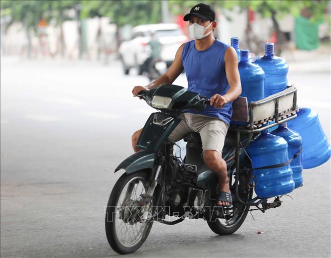 Trong ảnh: Nhân viên giao hàng không đội mũ bảo hiểm khi di chuyển trên phố (ảnh chụp sáng 10/8/2021). Ảnh: Thanh Tùng - TTXVN