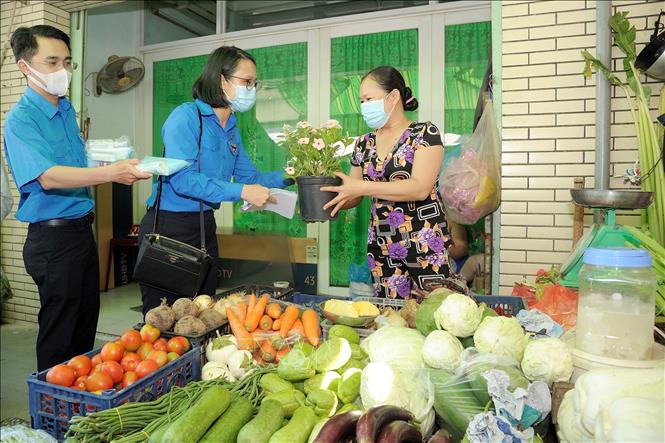 Trong ảnh: Các đoàn viên thanh niên thành phố Hồ Chí Minh tặng khẩu trang miễn phí cho tiểu thương chợ Lò Gốm (Quận 6) trong chương trình Ra quân thực hiện các hoạt động ý nghĩa của Tháng Thanh niên năm 2021. Ảnh: Hồng Giang - TTXVN.
