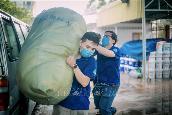 Trong ảnh: Thanh niên, tình nguyện viên thành phố Hồ Chí Minh vận chuyển nhu yếu phẩm, thực phẩm cho người dân các khu cách ly, khu phong toả tại quận Phú Nhuận. Ảnh: Hồng Giang - TTXVN