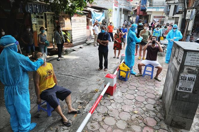 Trong ảnh: Nhân viên y tế lấy mẫu xét nghiệm cho toàn bộ người dân tại ngõ Lương Sử C, phường Văn Chương. Ảnh: Thành Đạt - TTXVN
