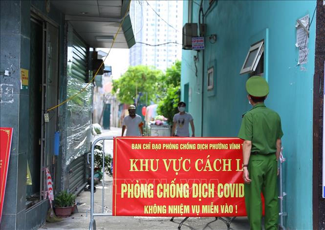 Trong ảnh: Lực lượng chức tiến hành phong tỏa khu vực có liên quan đến ca nhiễm COVID-19. Ảnh: Hoàng Hiếu - TTXVN 