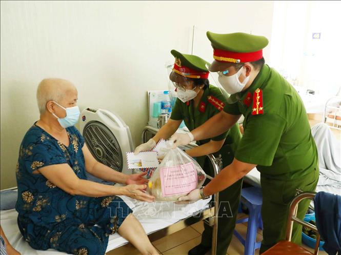 Trong ảnh: Cán bộ, chiến sỹ Công an phường Mai Dịch (quận Cầu Giấy, Hà Nội) trao quà hỗ trợ cho bệnh nhân có hoàn cảnh khó khăn đang điều trị tại trung tâm Ung Bướu, bệnh viện 19 - 8 Bộ Công an. Ảnh: Phạm Kiên - TTXVN