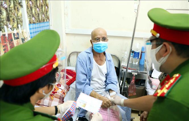 Trong ảnh: Cán bộ, chiến sỹ Công an phường Mai Dịch (quận Cầu Giấy, Hà Nội) trao quà hỗ trợ cho bệnh nhân có hoàn cảnh khó khăn đang điều trị tại trung tâm Ung Bướu, bệnh viện 19 - 8 Bộ Công an. Ảnh: Phạm Kiên - TTXVN