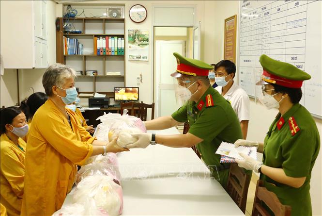 Trong ảnh: Cán bộ, chiến sỹ Công an phường Mai Dịch (quận Cầu Giấy, Hà Nội) trao quà hỗ trợ cho người nhà bệnh nhân có hoàn cảnh khó khăn đang điều trị tại Khoa điều trị tích cực và chống độc, bệnh viện 19 - 8 Bộ Công an. Ảnh: Phạm Kiên - TTXVN