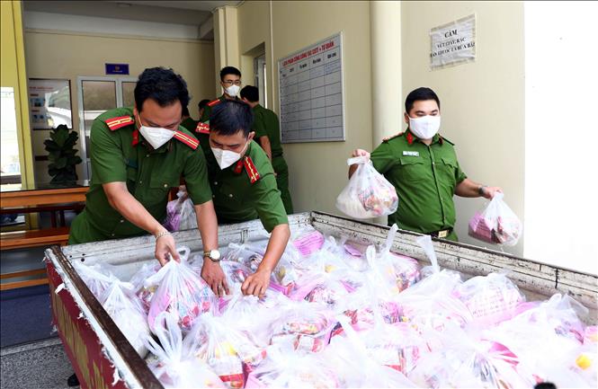 Trong ảnh: Cán bộ, chiến sỹ Công an phường Mai Dịch (quận Cầu Giấy, Hà Nội) sắp xếp những phần quà để trao tặng những người dân có hoàn cảnh khó khăn đang chịu ảnh hưởng của dịch bệnh COVID-19. Ảnh: Phạm Kiên - TTXVN