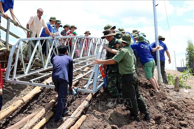Trong ảnh: Đoàn viên thanh niên Công an Kiên Giang tham gia làm cầu tại ấp Tràm Trổi, xã Vĩnh Điều, huyện Giang Thành. Ảnh: Lê Sen - TTXVN