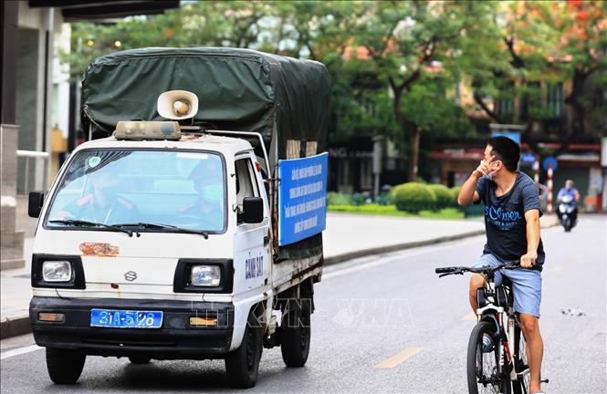 Trong ảnh: Công an phường Lê Đại Hành gọi loa nhắc nhở người dân ra đường đạp xe tập thể dục, nếu tiếp tục vi phạm sẽ tiến hành xử phạt trong những ngày thành phố thực hiện giãn cách. Ảnh: Thành Đạt - TTXVN